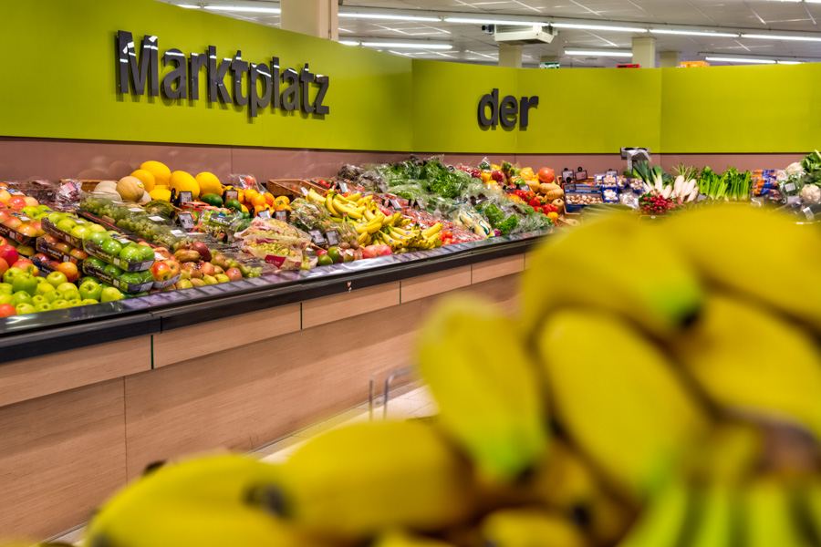EDEKA-Abroell-Bad-Groenenbach-Obst-und-Gemuese Obst- und Gemüseabteilung im Supermarkt mit großer Auslage; Bananen unscharf im Vordergrund.